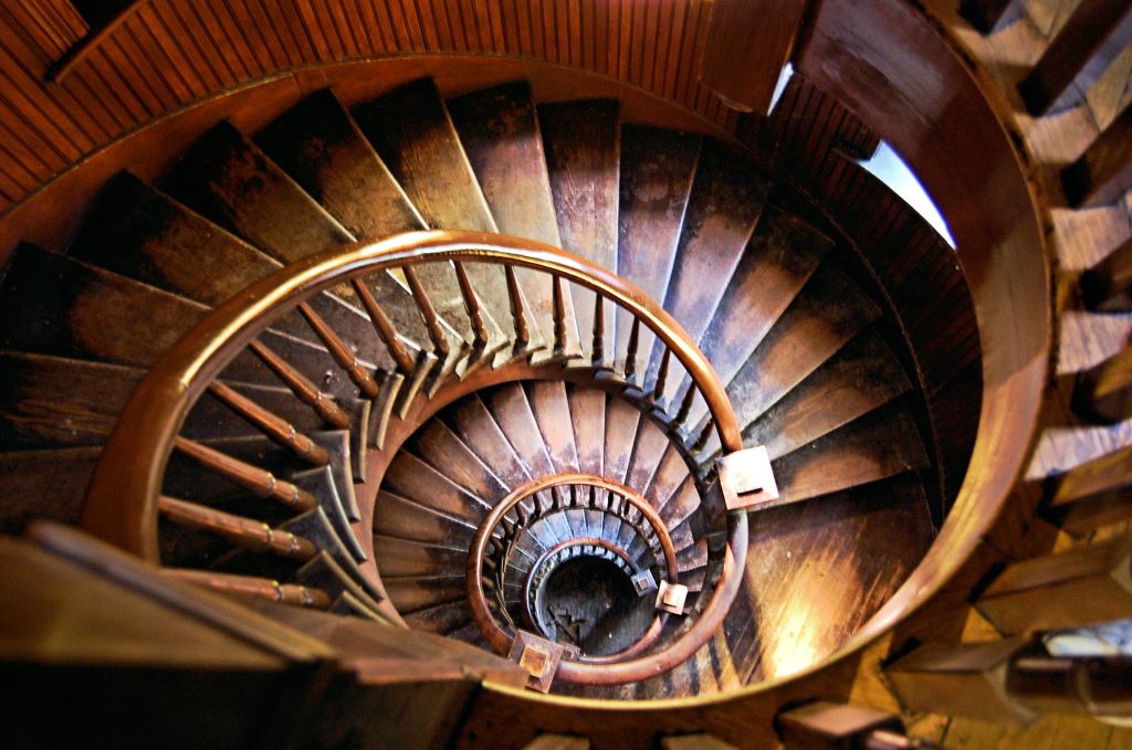 oval wooden spiral staircase that is well worn