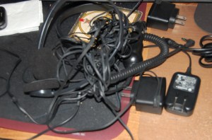 tangle of black cords to chargers, headphones, and such