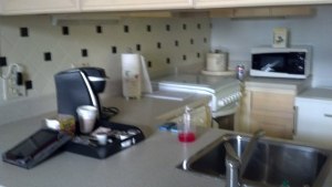 Blurry image of kitchen there to the right and below the microwave is the fridge.  To the left the stove.  Oh and yes they left us a cup of noodles in case you get in late and are hungry.