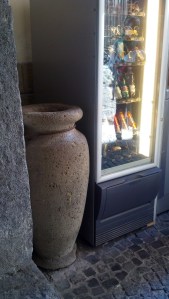 Ancient Roman wine urn next to modern vending.