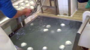 Mozzarella gets its name from the Italian word mozz meaning to cut.  Here is the modern way of cutting by machine.